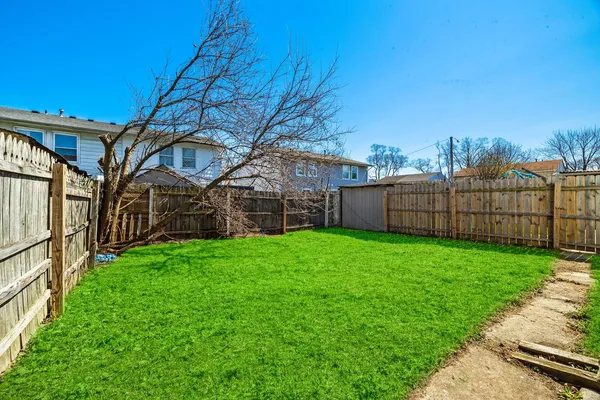 a view of a backyard with wooden fence