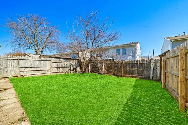 a view of yard with wooden fence and a bench
