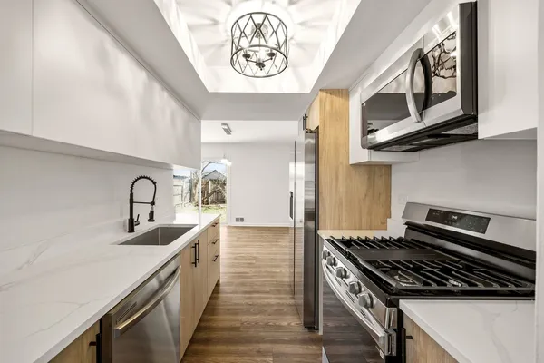 a kitchen with stainless steel appliances granite countertop a stove and a sink