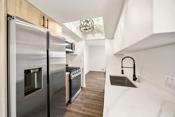 a kitchen with stainless steel appliances granite countertop a refrigerator and a sink