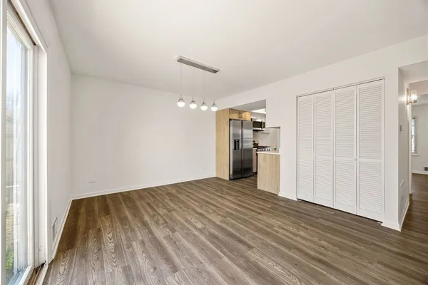 a view of empty room with wooden floor and window