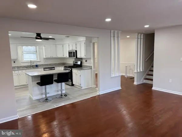 a kitchen with stainless steel appliances a dining table chairs and a refrigerator