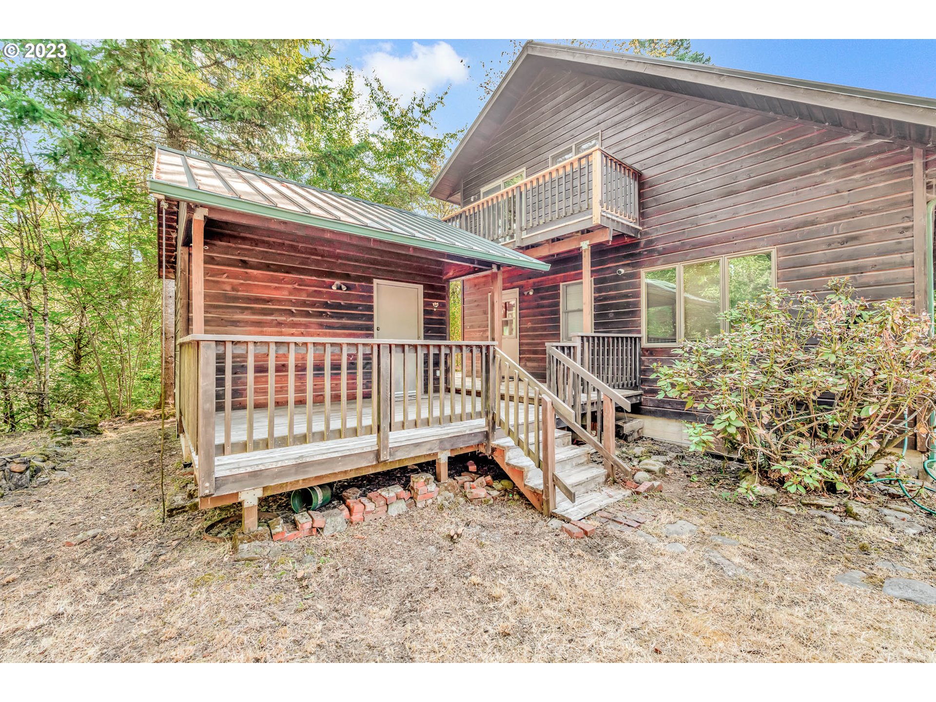 77383 Mosby Creek Road Cottage Grove, OR 97424 - Photo 31 of 48 a view of a house with a wooden deck and a yard