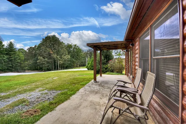 a view of a patio with a table chairs and a backyard