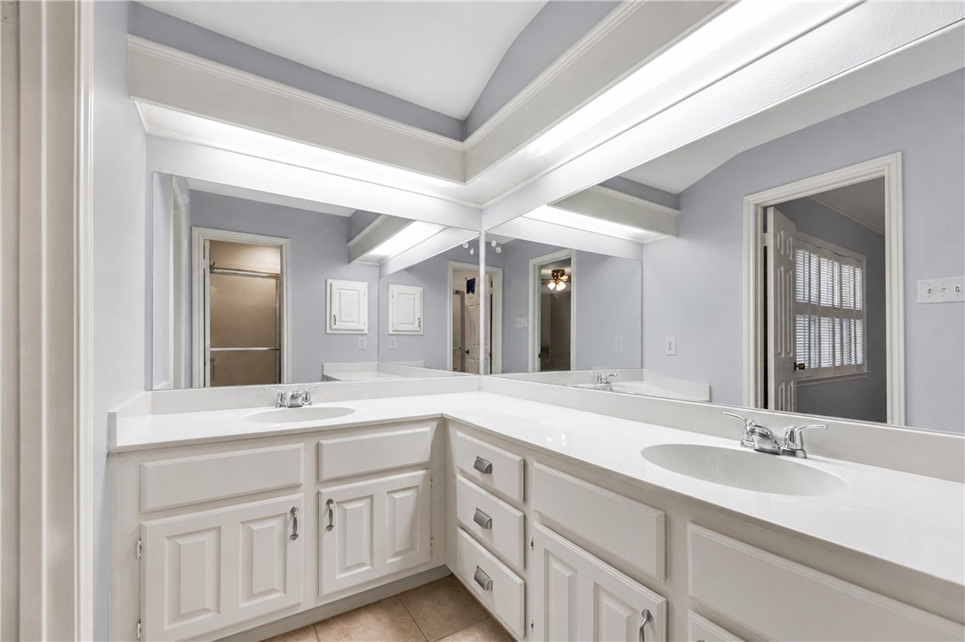 2911 Braeburn Street Bryan, TX 77802 - Photo 22 of 30 Bathroom featuring an extended vanity with two integrated sinks, white cabinetry, and a continuous mirror.