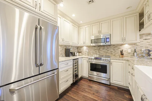a kitchen with stainless steel appliances white cabinets and a refrigerator
