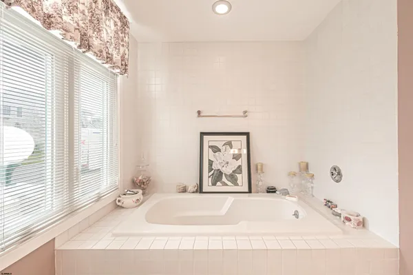 a bathroom with a tub sink and a window