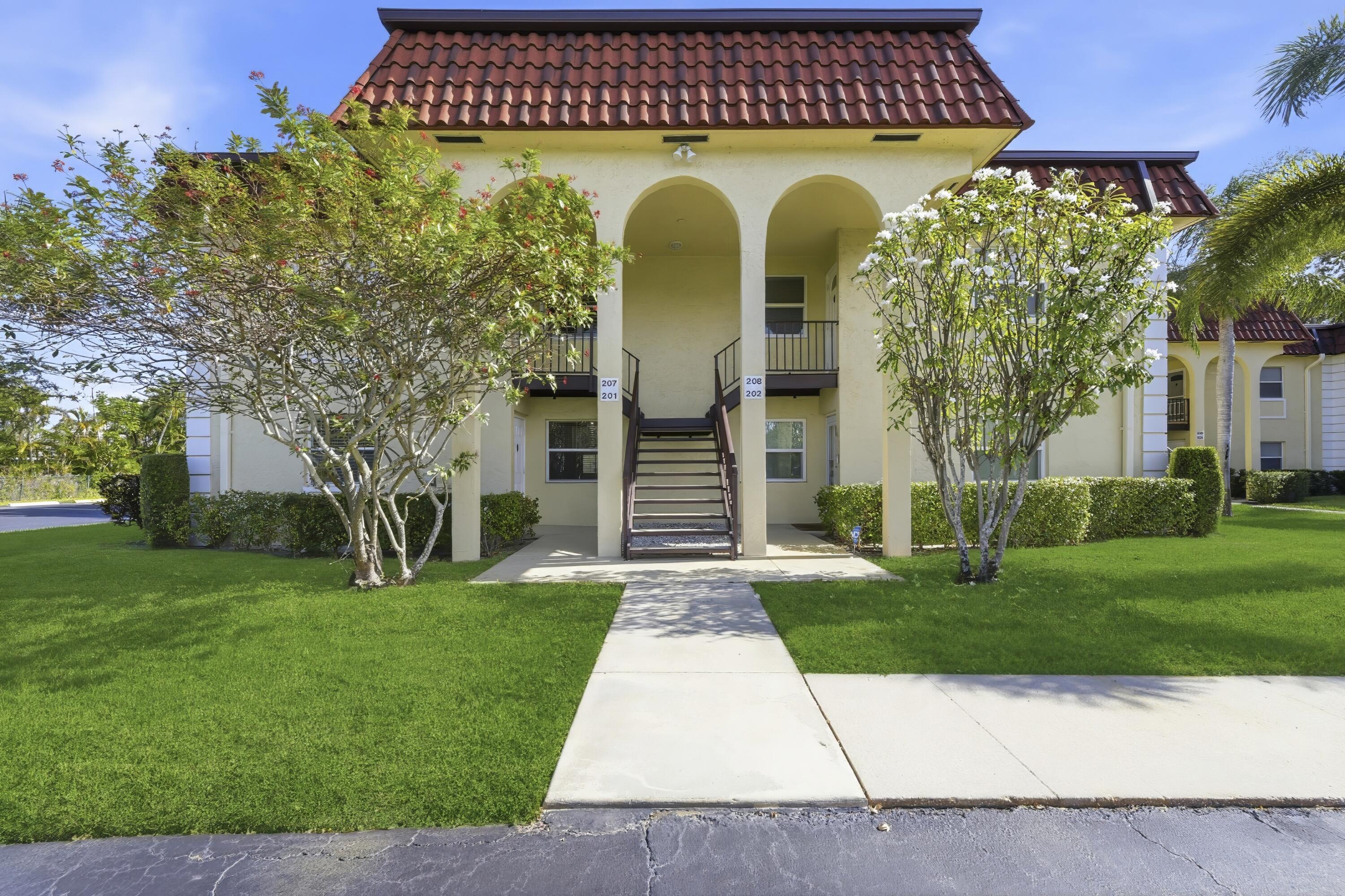 717 Highway 1, Unit 201 Jupiter, FL 33477 - Photo 1 of 31 a front view of a house with garden