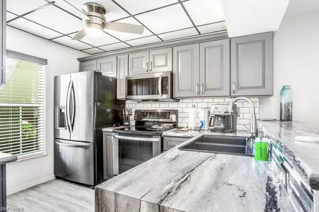 a kitchen with stainless steel appliances granite countertop a refrigerator a stove top oven a sink and dishwasher