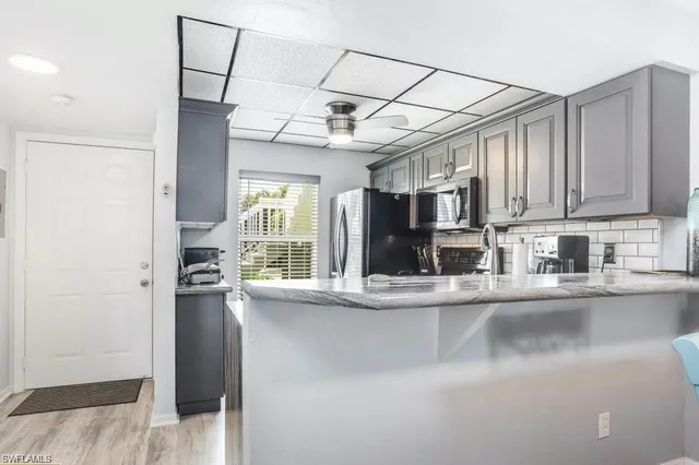 a view of a kitchen with stainless steel appliances granite countertop a refrigerator and cabinets