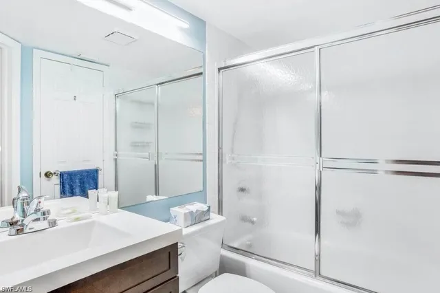 a bathroom with a bathtub shower sink vanity and toilet