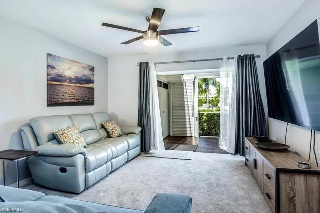 a living room with furniture a ceiling fan and a window