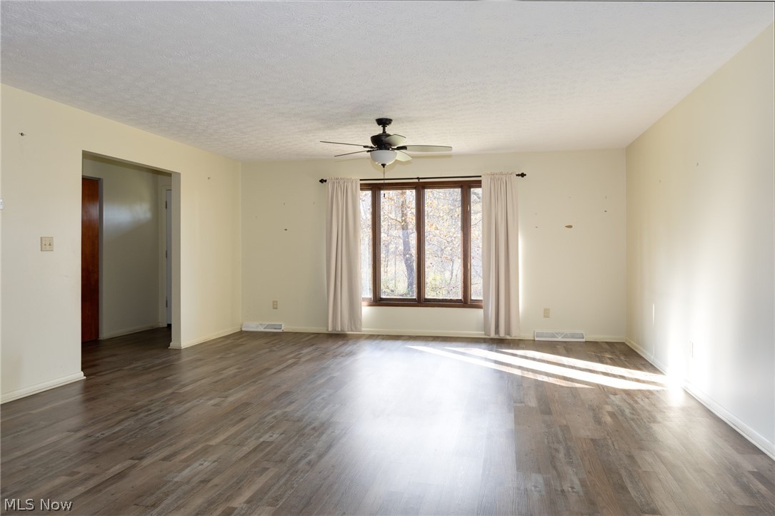 9416 Kieffer Road Mantua, OH 44255 - Photo 9 of 29 Living room with a ceiling fan, dark wood-type flooring, and a textured ceiling