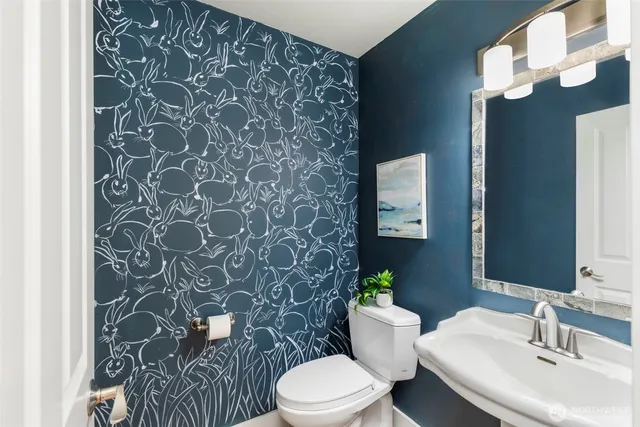 a bathroom with a toilet sink and mirror