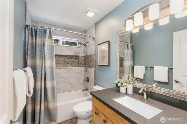 a bathroom with a granite countertop sink toilet and shower