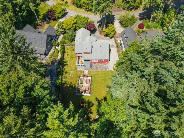an aerial view of residential house with outdoor space and trees all around