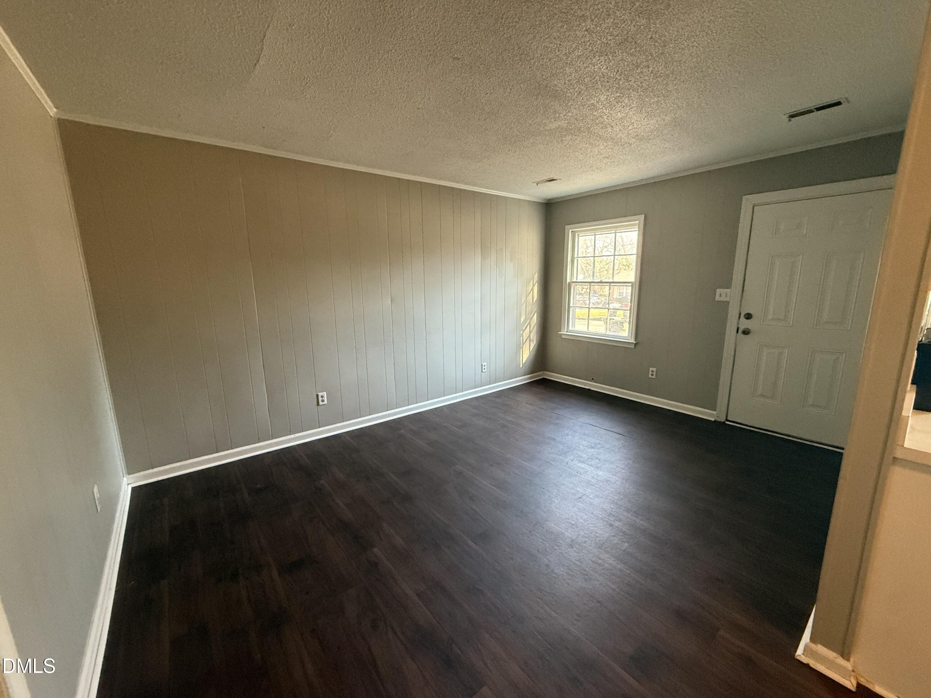 808 Crawford Street South Wilson, NC 27893 - Photo 10 of 11 an empty room with wooden floor and windows