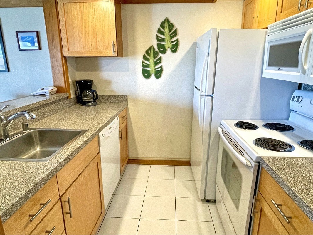 2253 Poipu Road, Unit 317 Koloa, HI 96756 - Photo 11 of 16 a kitchen with a sink a stove top oven a refrigerator and a sink
