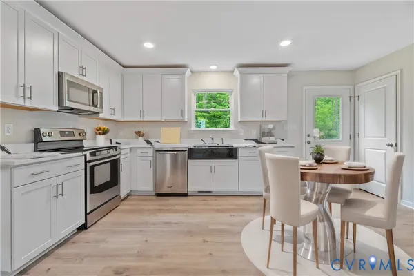 a kitchen with a stove a sink and white cabinets