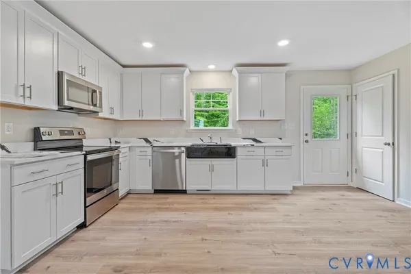 a kitchen with granite countertop white cabinets and white stainless steel appliances