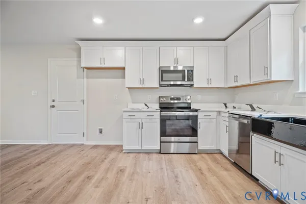 a kitchen with cabinets stainless steel appliances and sink