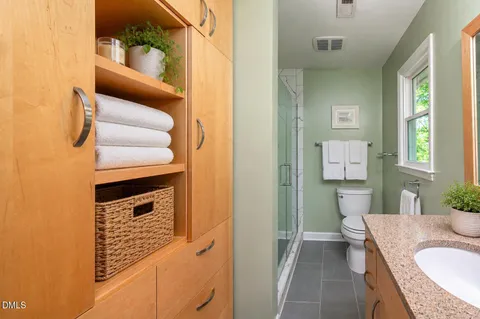 a bathroom with a sink vanity mirror and toilet