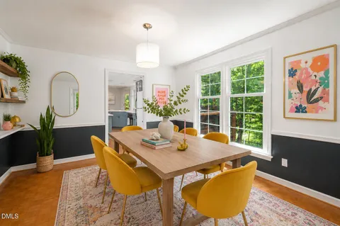 a dining area with stainless steel appliances granite countertop a dining table chairs refrigerator and sink