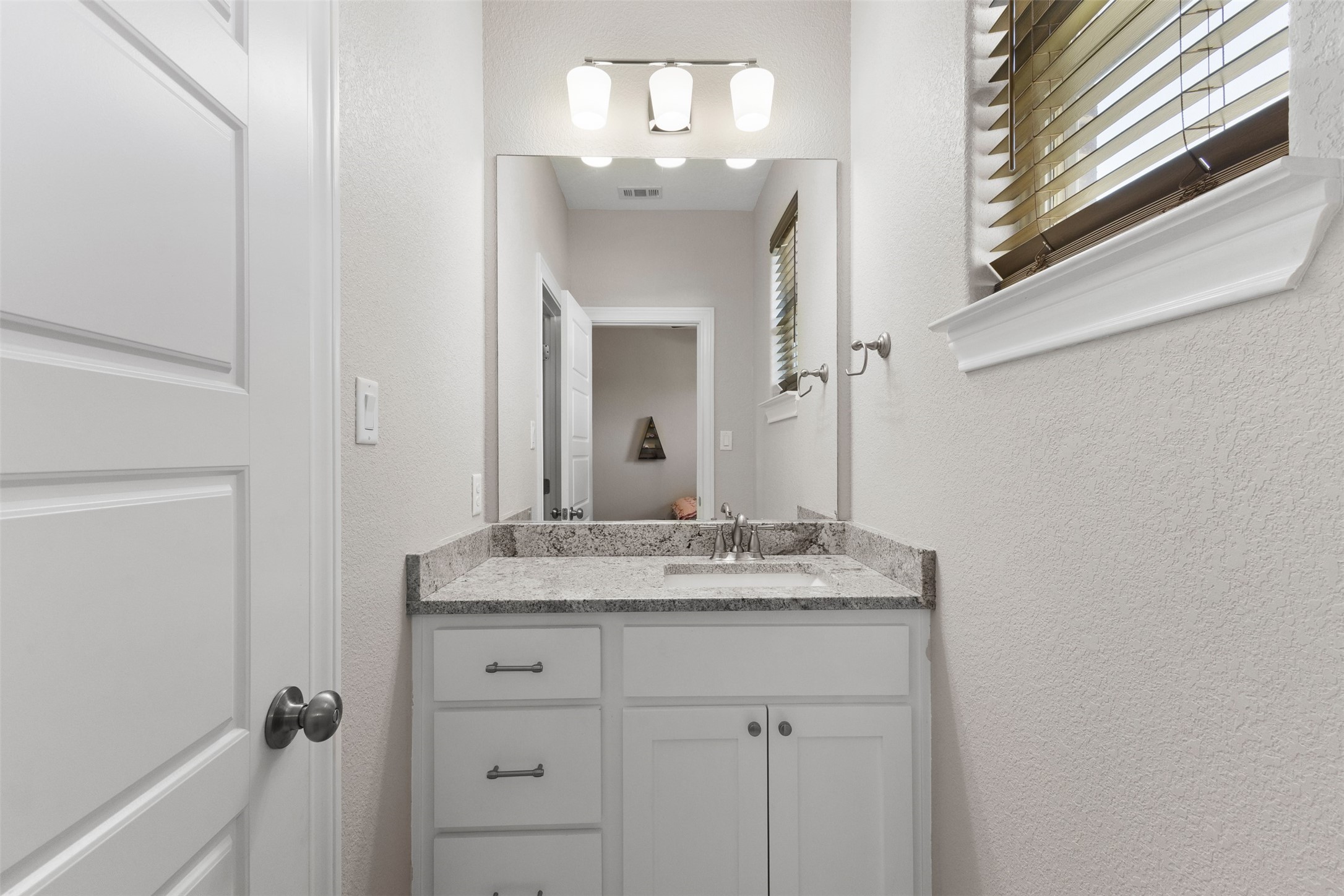 3010 Nobel Court Bryan, TX 77808 - Photo 14 of 23 a bathroom with a granite countertop sink a mirror and a vanity
