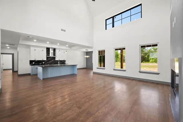 a view of kitchen with kitchen island wooden floor and stainless steel appliances