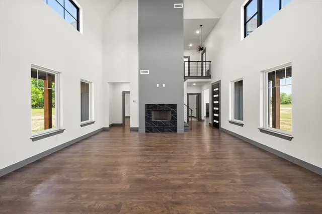 a view of a livingroom with wooden floor and a fireplace