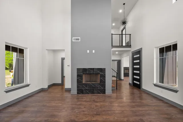 an empty room with fireplace wooden floor and windows