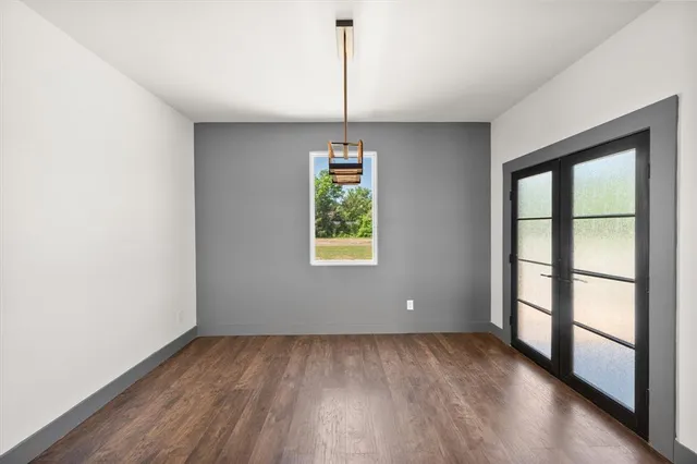 a view of an empty room with window wooden floor and a window