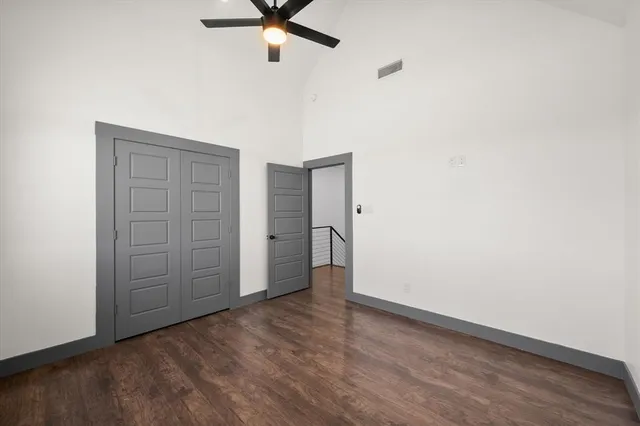 an empty room with a hardwood and ceiling fan