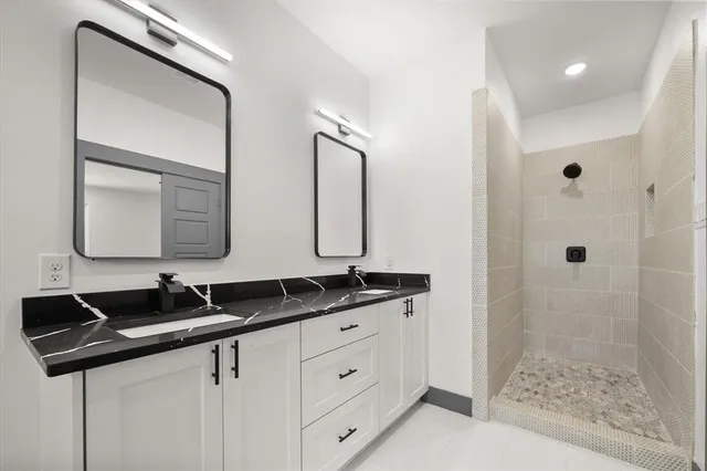 a bathroom with double sink and a mirror