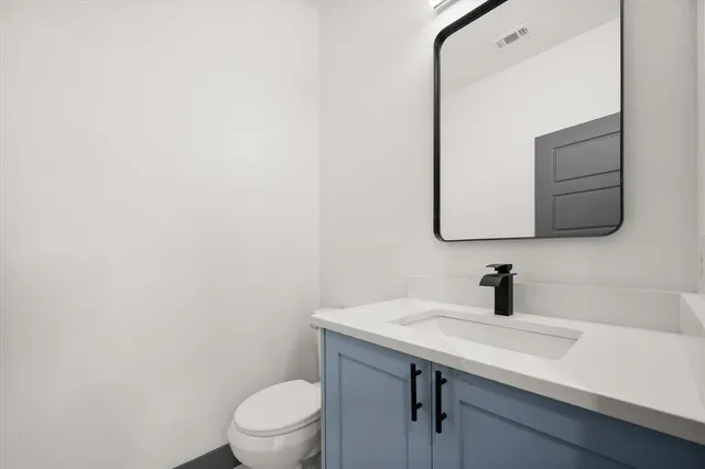 a bathroom with a sink a toilet and mirror