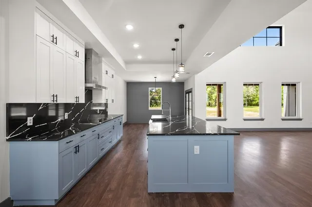a kitchen with granite countertop a sink a counter top space and stainless steel appliances