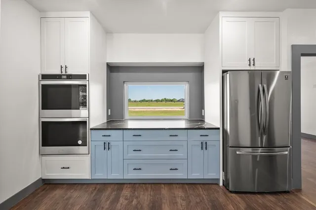 a kitchen with granite countertop white cabinets and stainless steel appliances