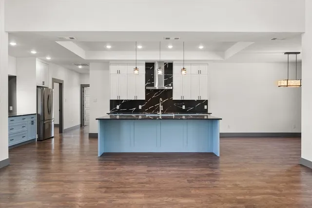 a view of kitchen with stainless steel appliances granite countertop a stove and a refrigerator