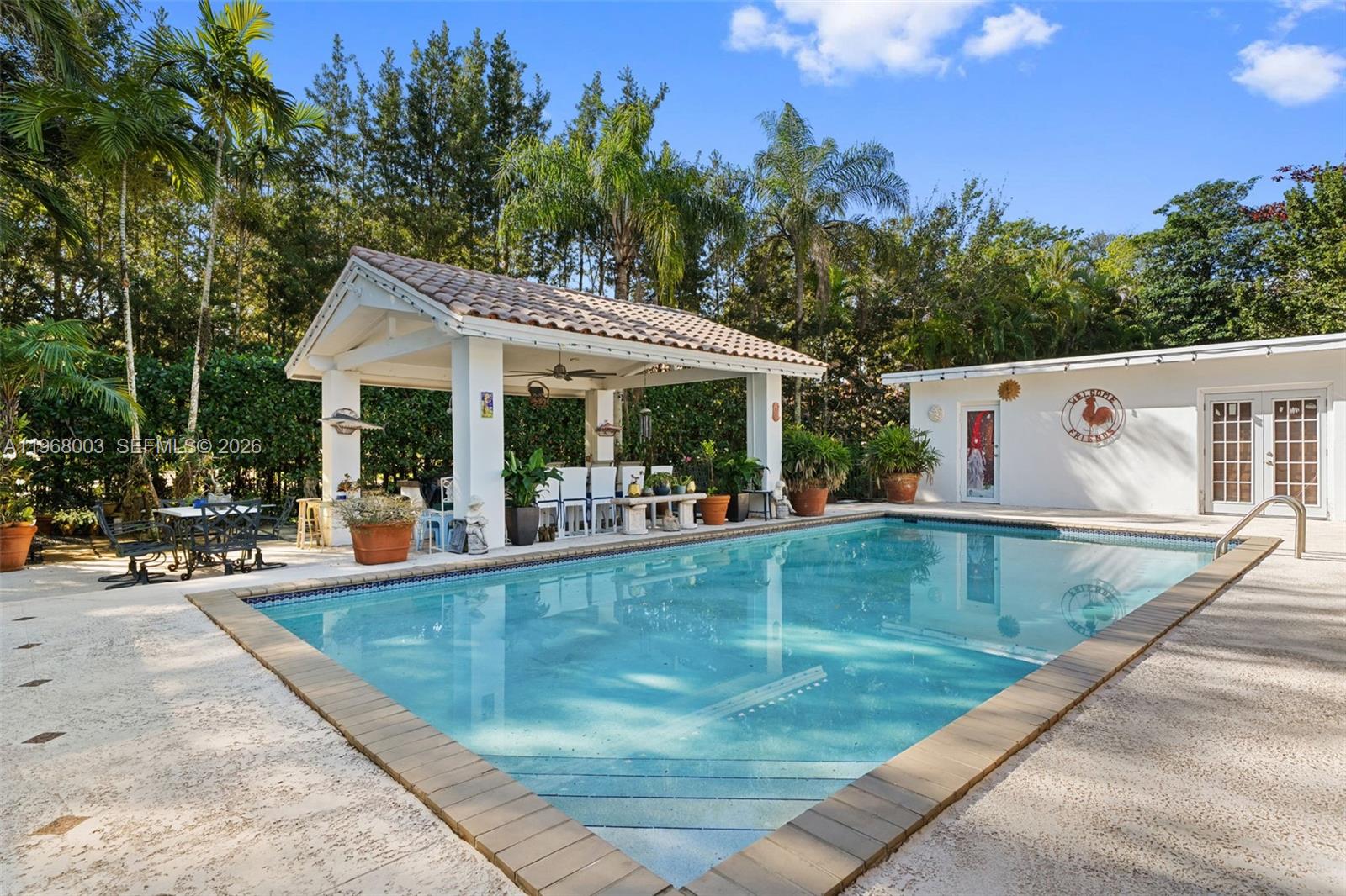 11220 Southwest 67th Avenue Pinecrest, FL 33156 - Photo 14 of 42 swimming pool view with a seating space and a garden view