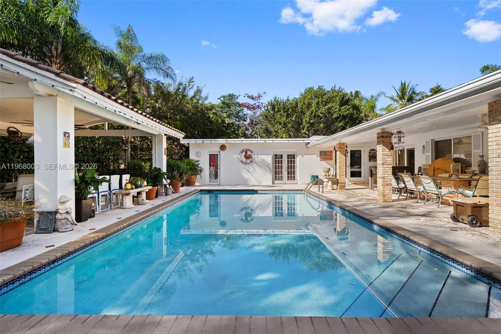 11220 Southwest 67th Avenue Pinecrest, FL 33156 - Photo 15 of 42 a view of a white house with a swimming pool