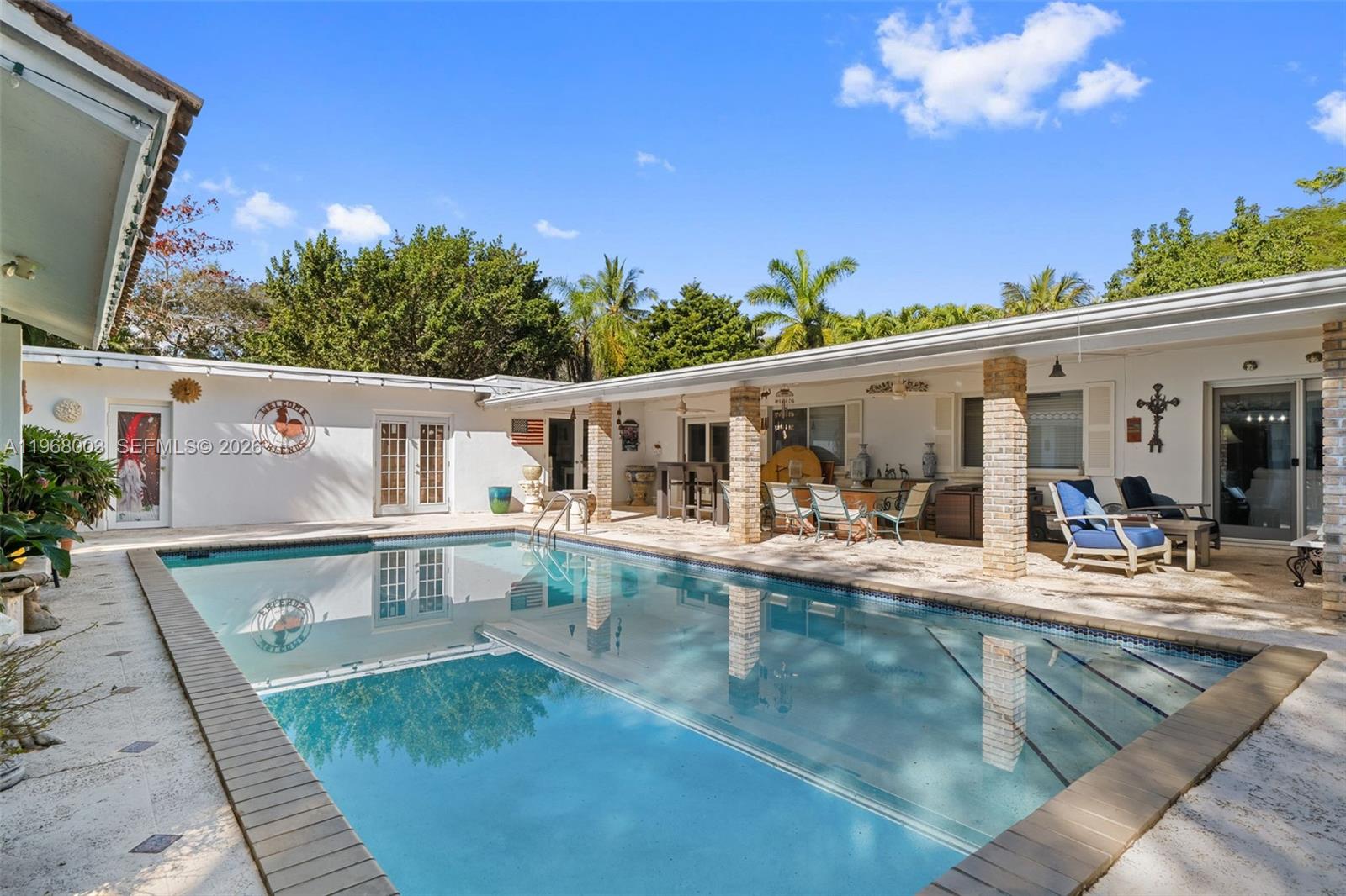 11220 Southwest 67th Avenue Pinecrest, FL 33156 - Photo 16 of 42 swimming pool view with a seating space and a garden