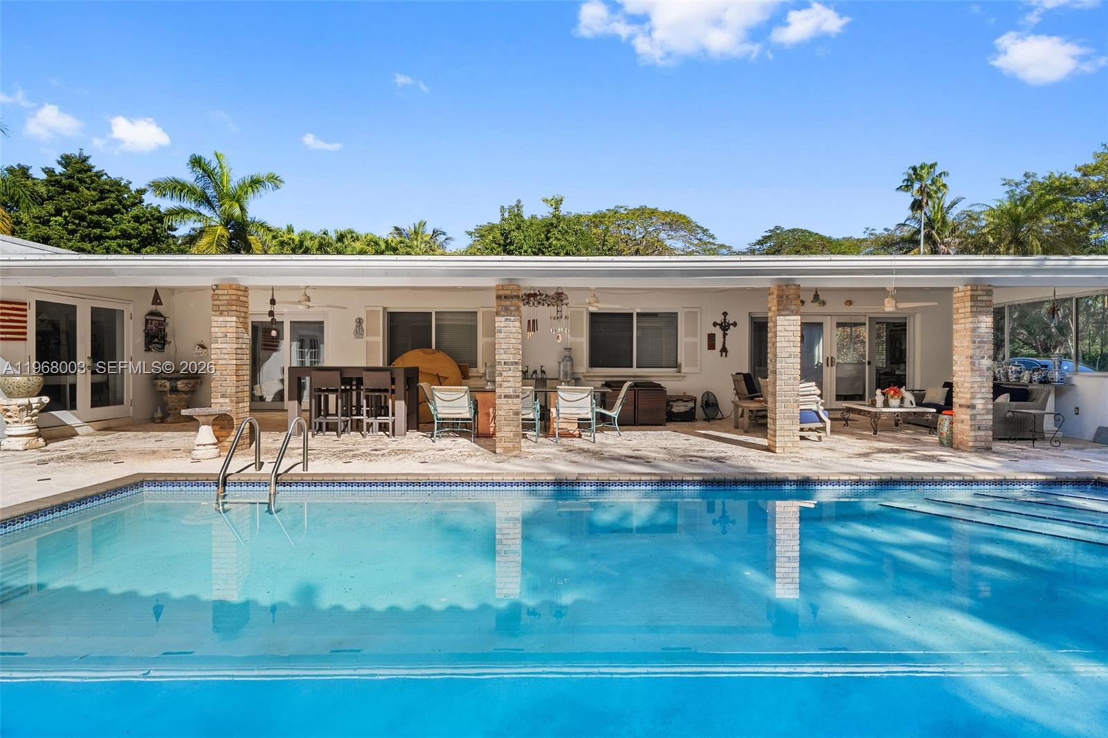 11220 Southwest 67th Avenue Pinecrest, FL 33156 - Photo 17 of 42 a view of a swimming pool with outdoor seating