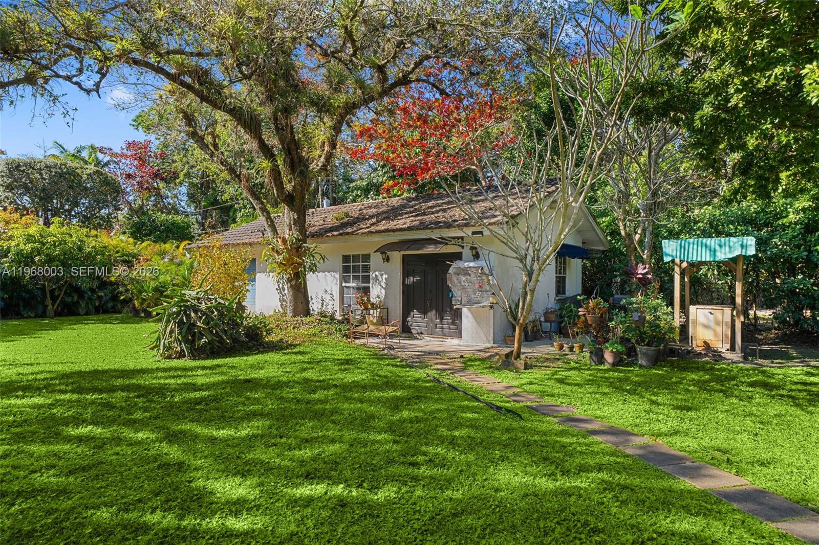 11220 Southwest 67th Avenue Pinecrest, FL 33156 - Photo 26 of 42 a view of a house with a yard