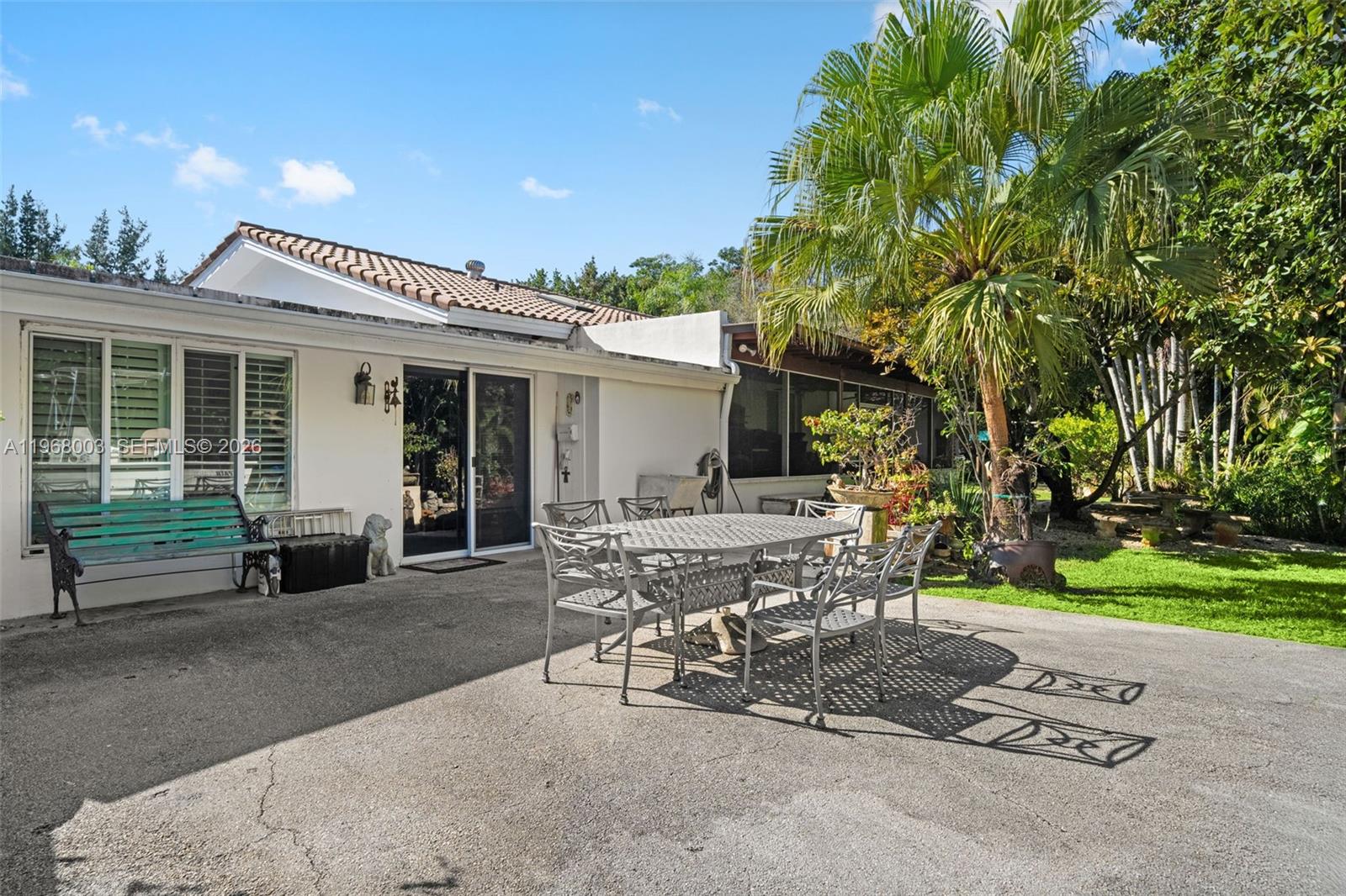 11220 Southwest 67th Avenue Pinecrest, FL 33156 - Photo 30 of 42 a view of a patio with table and chairs and potted plants