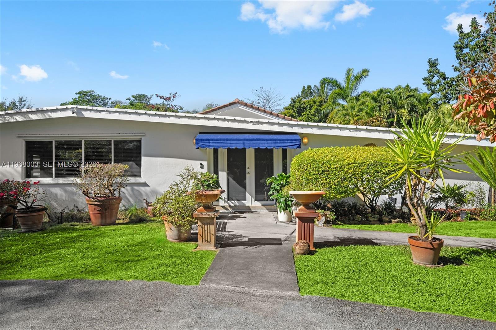 11220 Southwest 67th Avenue Pinecrest, FL 33156 - Photo 38 of 42 a front view of a house with garden and porch