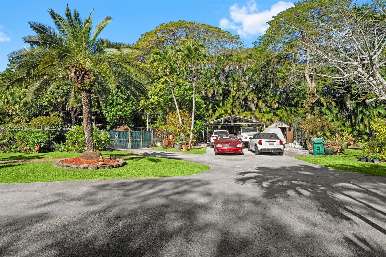 11220 Southwest 67th Avenue Pinecrest, FL 33156 - Photo 42 of 42 a view of a car parked in front of a house with large trees