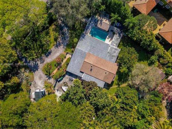 an aerial view of a house with a yard and trees