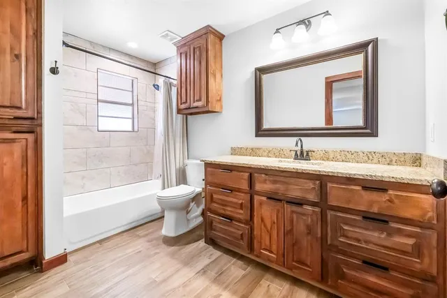 a bathroom with a double vanity sink a toilet and a mirror