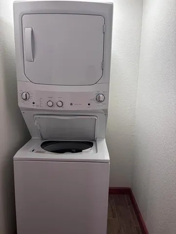 an empty room with wooden floor fireplace and windows