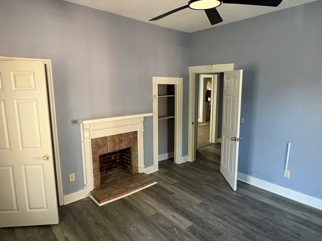 2427 Marion Street Columbus, GA 31906 - Photo 20 of 23 an empty room with wooden floor fireplace and windows